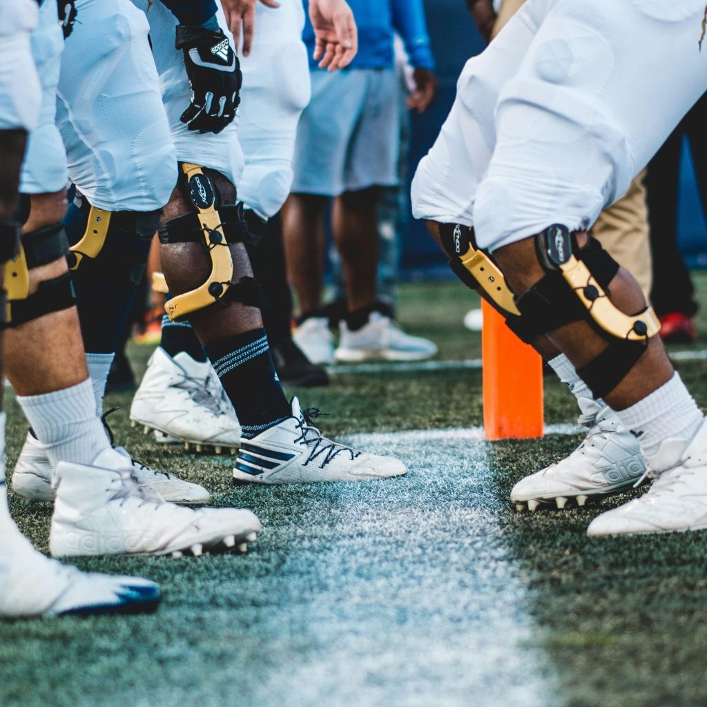 Sports players wearing hinged knee braces for joint protection and stability