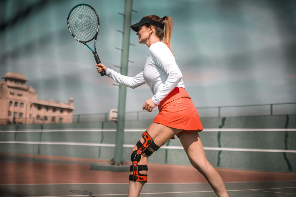 Athlete wearing hinged knee brace for sports support and knee stability