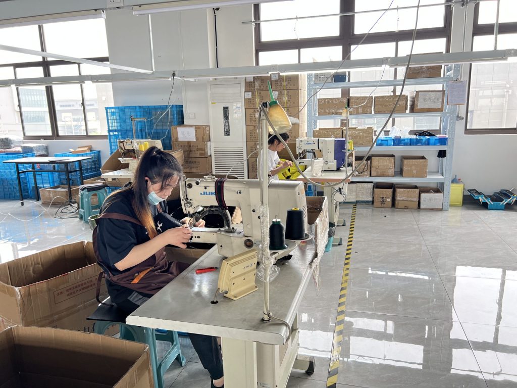 Workers sewing knee support products in manufacturing facility